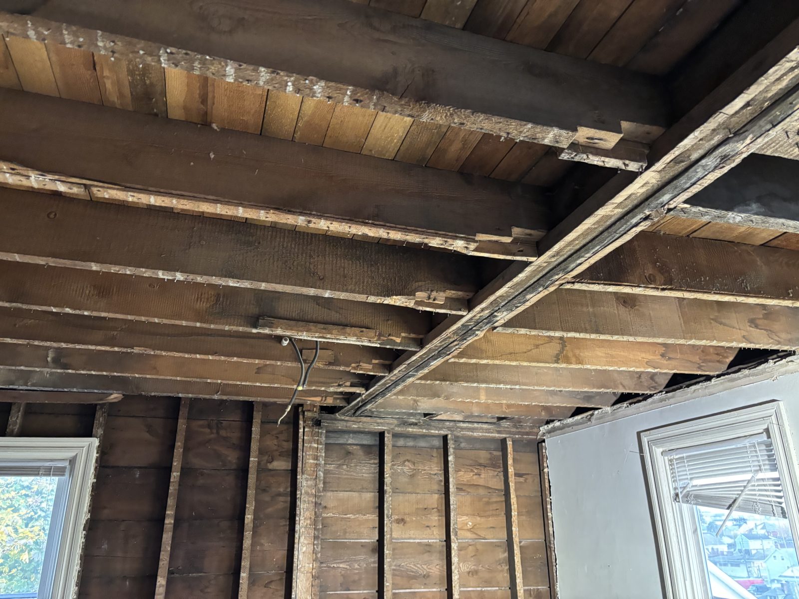 Before: original ceiling joists and wood beam exposed during renovation